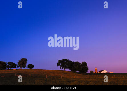 Sonnendurchflutetes Bauernhaus unter einem lebendigen Sonnenuntergang Himmel in Lancaster County, Pennsylvania. USA. Stockfoto