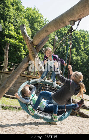 Drei Mädchen schwingen auf einer Schaukel Spielplatz, München, Bayern, Deutschland Stockfoto