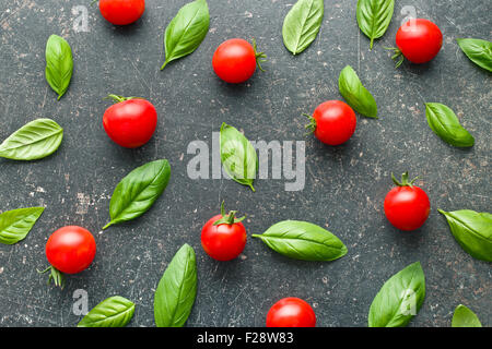 Tomaten und Basilikum Blätter am Küchentisch Stockfoto
