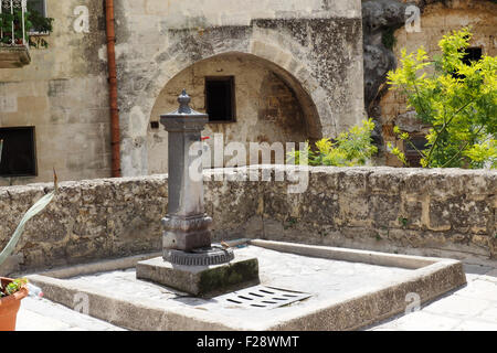 Trinkbrunnen und Sandstein-Gebäude. Stockfoto