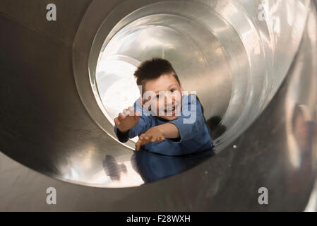 Junge, die Schiebetüren in einer Tunnelrutsche, München, Bayern, Deutschland Stockfoto