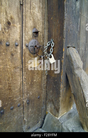 Mit zwei Vorhängeschlösser Tür von einem verlassenen baufälligen alten Haus gesperrt. Stockfoto