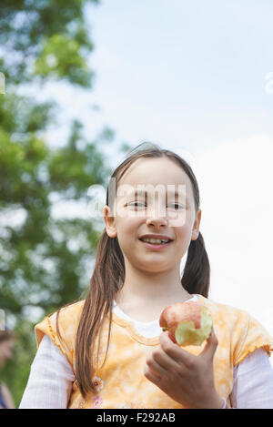 Porträt eines Mädchens hält einen gegessen Apfel, Bayern, Deutschland Stockfoto