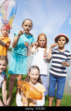 Kinder Seifenblasen mit Blase Zauberstäbe, Bayern, Deutschland Stockfoto