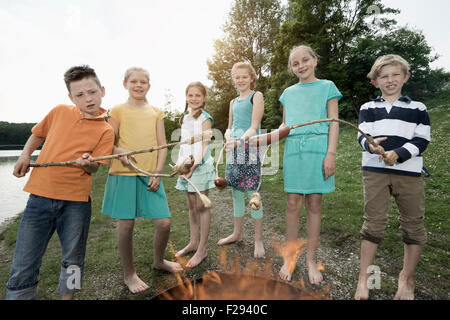 Gruppe von Freunden vorbereiten Würstchen am Lagerfeuer, Bayern, Deutschland Stockfoto