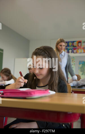 Schulmädchen, die in Notizbuch schreiben, München, Bayern, Deutschland Stockfoto