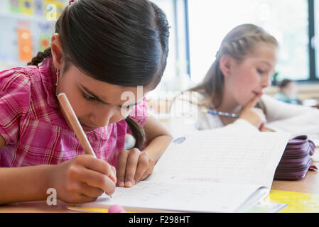 Schulmädchen, die in Notizbüchern schreiben, München, Bayern, Deutschland Stockfoto