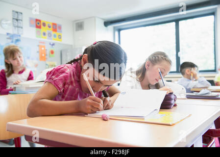 Schulschüler, die in Notizbüchern schreiben, München, Bayern, Deutschland Stockfoto