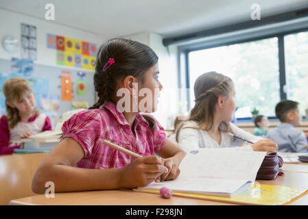 Schulschüler, die in Notizbüchern schreiben, München, Bayern, Deutschland Stockfoto