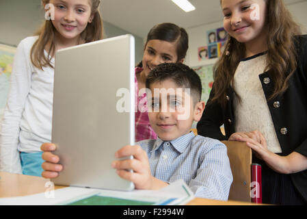 Schülerinnen und Schüler mit einem digitalen Tablet im Klassenzimmer, München, Bayern, Deutschland Stockfoto