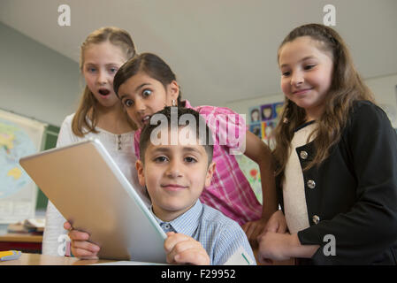 Schülerinnen und Schüler mit einem digitalen Tablet in einem Klassenzimmer, München, Bayern, Deutschland Stockfoto
