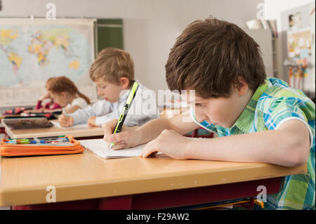 Schulschüler, die in Notizbüchern schreiben, München, Bayern, Deutschland Stockfoto