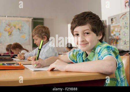 Schulschüler, die in Notizbüchern schreiben, München, Bayern, Deutschland Stockfoto