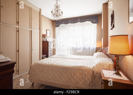 Altes Schlafzimmer mit Queensize-Bett im gemütlichen Haus Stockfoto