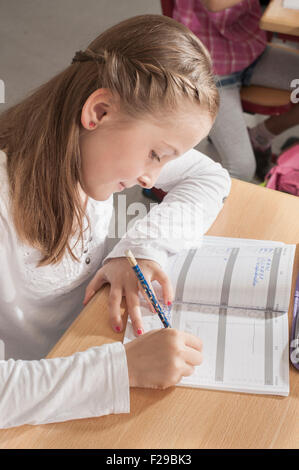 Schulmädchen schreibt in Notizbuch, München, Bayern, Deutschland Stockfoto