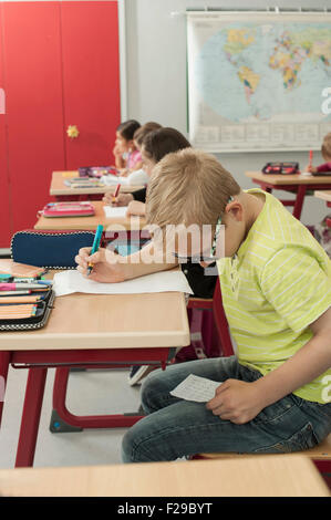 Schuljunge betrügt bei einem Test im Klassenzimmer, München, Bayern, Deutschland Stockfoto