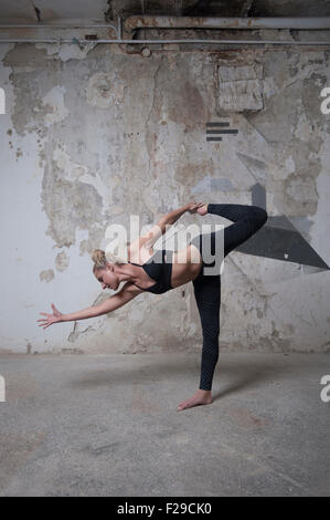Mitte Erwachsene Frau üben Zuckerrohr Pose im Yoga-Studio, München, Bayern, Deutschland Stockfoto