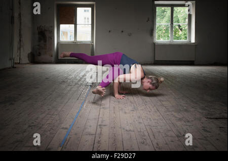 Mitte Erwachsene Frau üben Eka Pada Koundinyasana posiere ich im Yoga-Studio, München, Bayern, Deutschland Stockfoto