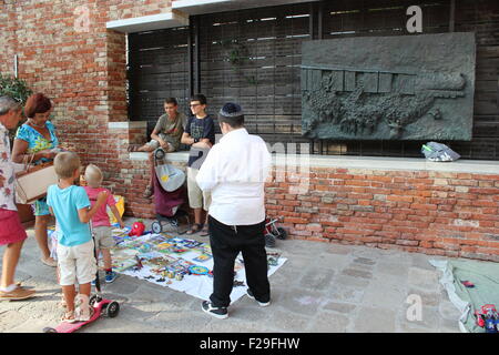 Jüdische Kinder spielen neben einem Holocaust-Mahnmal im alten Ghetto, Venedig, Italien Stockfoto