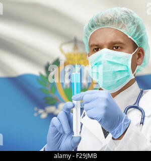 Arzt mit Spritze in Händen und Flagge auf Hintergrund-Serie - San Marino Stockfoto