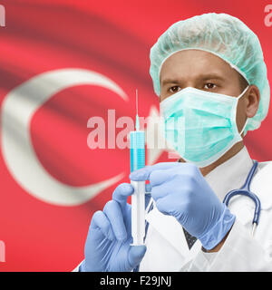 Arzt mit Spritze in Händen und Flagge auf Hintergrund-Serie - Türkei Stockfoto