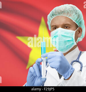 Arzt mit Spritze in Händen und Flagge auf Hintergrund-Serie - Vietnam Stockfoto