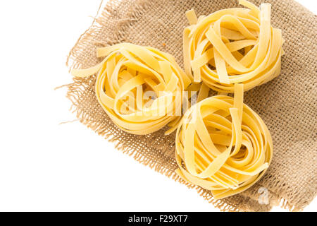 Italienische Pasta Nudel nisten auf Stück Sack auf weißem Hintergrund Stockfoto