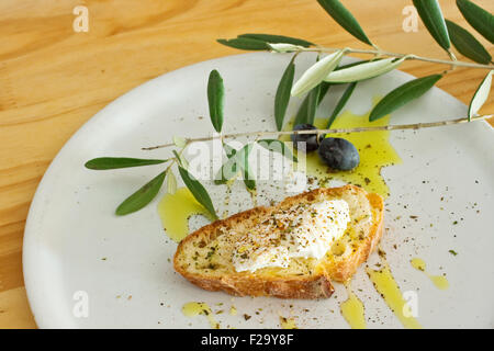 Brot, Ricotta-Käse und Olivenöl auf Teller Stockfoto