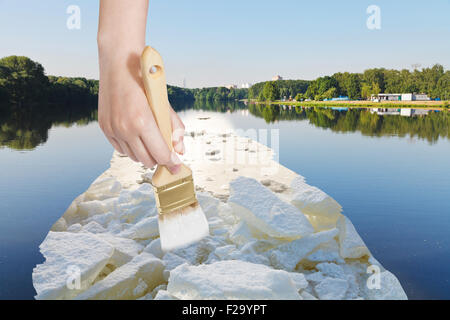 Natur-Konzept - Jahreszeiten und Wetter ändert - Hand mit Pinsel malt Eisblöcke in See im Sommer Stockfoto