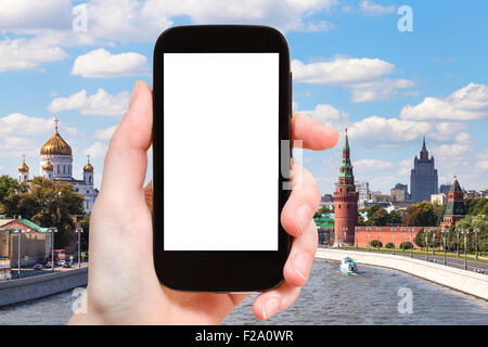 Konzept - Hand hält, das Smartphone mit Bildschirm und Moskau Landschaft auf Hintergrund ausschneiden zu reisen Stockfoto