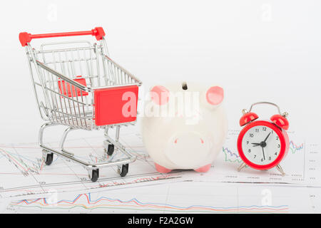 Warenkorb mit Sparschwein und Uhr Stockfoto