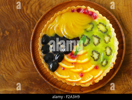 Obstkuchen mit verschiedenen Beeren (Trauben, Pfirsiche, Kiwi, Orange) Stockfoto