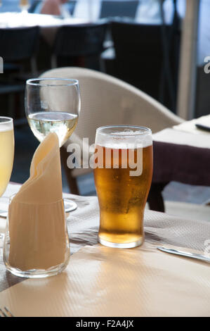 Pint Bier und ein Glas Wein auf einem Tisch. Stockfoto