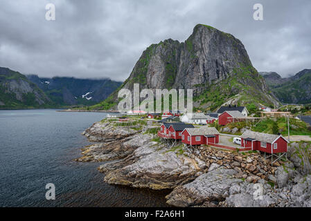 Traditionelle rote Rorbu-Hütten unter Lilandstinden Gipfel in Hamnoy Dorf, Lofoten Inseln, Norwegen. Stockfoto