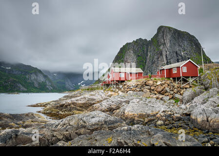 Traditionelle rote Rorbu-Hütten unter Lilandstinden Gipfel in Hamnoy Dorf, Lofoten Inseln, Norwegen. Langzeitbelichtung. Stockfoto