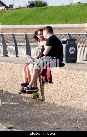 ein junges Paar genießen jede andere Firma auf Southsea Seafront England uk Stockfoto