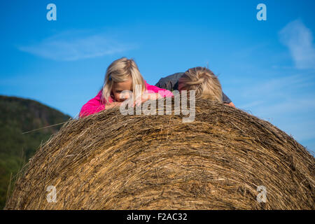 Kinder blond Mädchen und jungen (Geschwister) ruht auf Heuballen, Sommer, Urlaub, relaxen Stockfoto