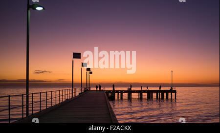 Silhouetten von Menschen zu Fuß auf einem Pier bei Sonnenuntergang, Victoria, Australien Stockfoto