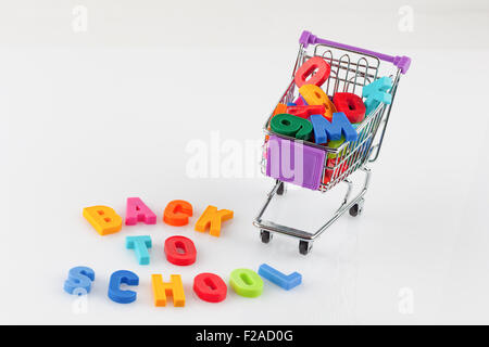Spielzeug Warenkorb gefüllt mit Buchstaben und Zahlen - zurück zum Schulkonzept isoliert auf weiss Stockfoto