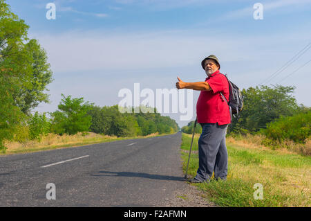 Senior Tramper stehend auf einem Straßenrand in der Ukraine im Sommer Stockfoto