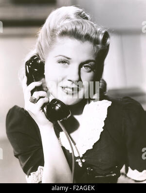 Blonde Frau hält Telefonhörer (OLVI008 OU144 F) Stockfoto