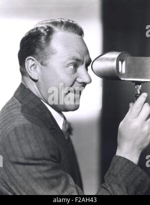 Mann sucht durch einen Sucher (OLVI008 OU027 F) Stockfoto