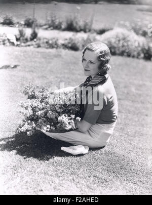 Frau sitzt mit Korb mit Blumen (OLVI007 OU971 F) Stockfoto