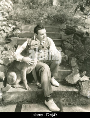 Junger Mann, sitzend mit Hund auf Schritte im Freien (OLVI007 OU838 F) Stockfoto