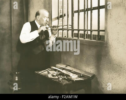 Mann Sägen durch Bars (OLVI007 OU613 F) Stockfoto