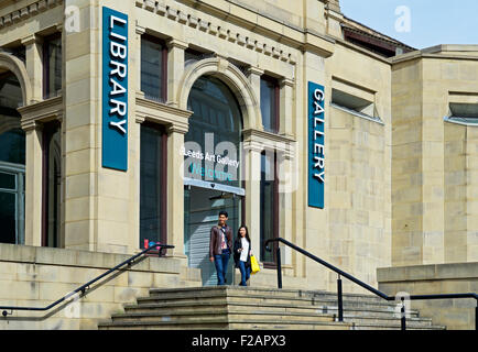 Junge asiatische paar verlassen Leeds Bibliothek und Kunstgalerie, Headrow, Leeds, West Yorkshire, England UK Stockfoto