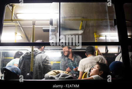 Ein syrischer Flüchtlingskind wartet die Übertragung nach Österreich schläft in den Bus an der Verladestation in Roszke, Ungarn, auf 14.09.2015. Die meisten Flüchtlinge hatte die Grenze überschritten, kurz bevor der Grenzzaun zwischen Serbien und Ungarn geschlossen wurde. Foto: Gregor Fischer/dpa Stockfoto