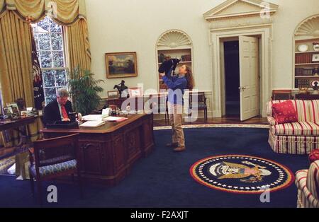 Chelsea Clinton die Katze im Oval Office mit Socken spielen. Auf der linken Seite, Präsident Bill Clinton arbeitet an seinem Schreibtisch. 24. Dezember 1994. (BSLOC 2015 2 201) Stockfoto