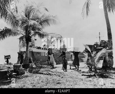 Menschen des Bikini-Atolls tragen ihr Hab und gut nach unten zum Boot. 40 Familien wanderten "vorübergehend" zu Rongerik-Atoll am 7. März 1946. Ihre Verdrängung war dauerhaft, weil die Atomexplosion BAKER und nach Tests, bestrahlt die Bikini-Insel, so dass es unbewohnbar. 23 Nuklearsprengsätze detonierten in der Bikini-Nähe zwischen 1946 und 1958 an sieben Teststellen. (BSLOC 2015 2 11) Stockfoto