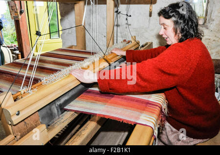 Eine Frau webt Leinen Textil mit einem traditionellen Webstuhl Stockfoto